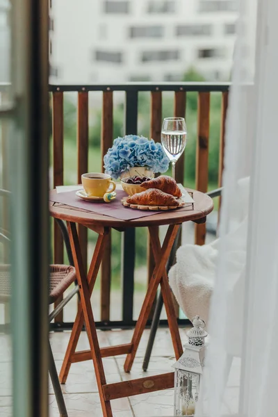 Balkonda sabah kahvaltısı, kruvasan, kahve ve böğürtlen.