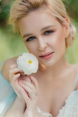 Baharın çiçek açan bahçesinde gelinlik giymiş güzel bir gelin.