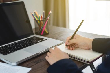 İş kadını yazma eller veya ofis, çalışma masası ve dizüstü bilgisayar, iş kavramı kitapta Not almak