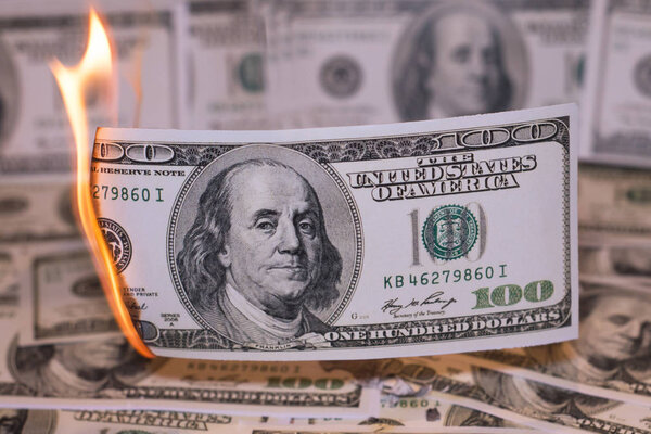 A hunred dollar bill in American US currency is on fire