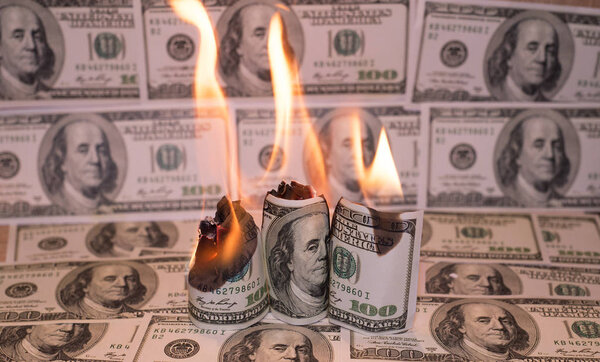 A hunred dollar bill in American US currency is on fire
