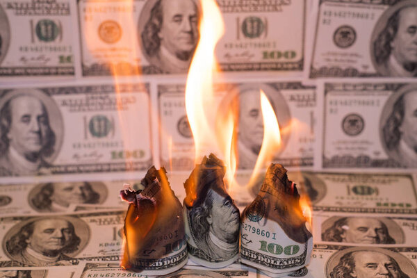A hunred dollar bill in American US currency is on fire