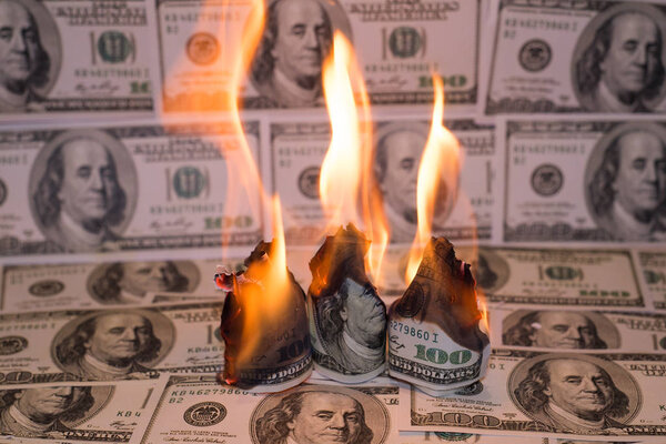 A hunred dollar bill in American US currency is on fire