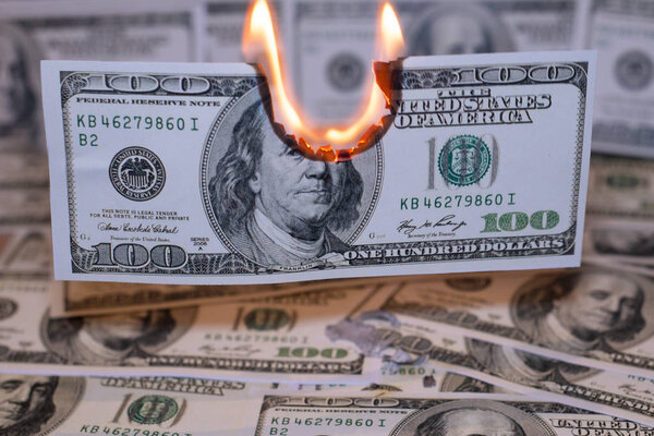 A hunred dollar bill in American US currency is on fire