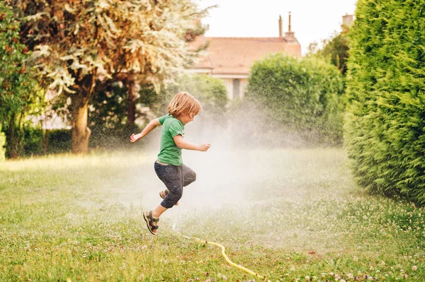 Criança Brincando Com Aspersor Jardim Pulando — Fotografia de Stock