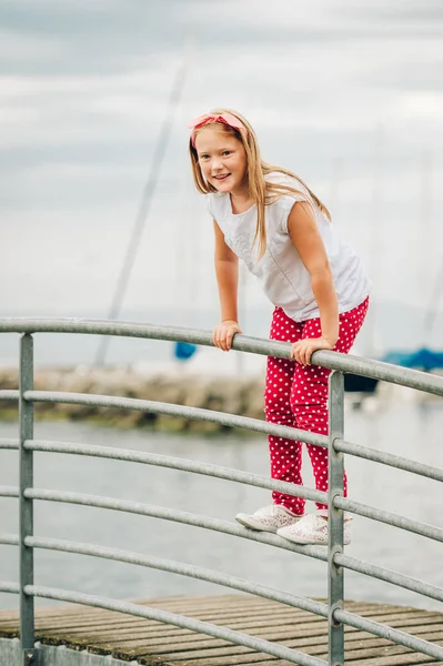 幸せな 歳の女の子のアウトドア楽しんで 素敵な暖かい日当たりの良い夜の湖で遊んで シャツと靴 赤い水玉パンツ ヘッドバンドを身に着けています 湖ジュネーブ スイス連邦共和国で撮影した画像 — ストック写真