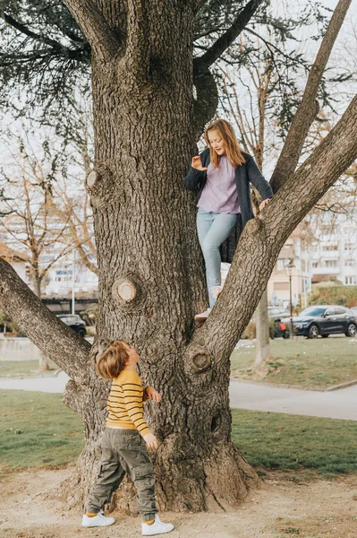 Dvě Vtipné Děti Hrají Venku Jaře Parku Lezení Strom Bratr — Stock fotografie