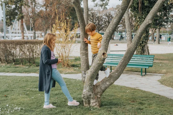 Двое Забавных Детей Играют Улице Весеннем Парке Забираются Дерево Брат — стоковое фото