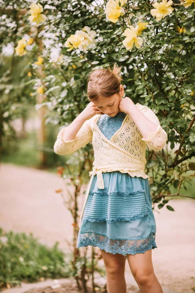 愛らしいプレティーン 歳の少女の美しいバラ園で 青いドレスと黄色のジャケットを着て屋外のポートレート — ストック写真