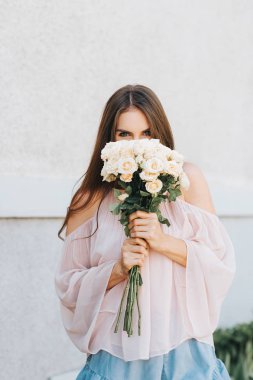 Allık soğuk omuz bluz giyen mutlu güzel kadın yumuşak beyaz güllü