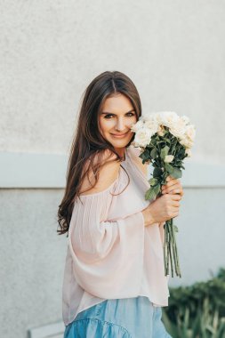 Allık soğuk omuz bluz giyen mutlu güzel kadın yumuşak beyaz güllü