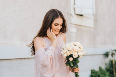 Allık soğuk omuz bluz giyen mutlu güzel kadın yumuşak beyaz güllü