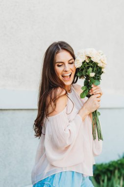 Allık soğuk omuz bluz giyen mutlu güzel kadın yumuşak beyaz güllü