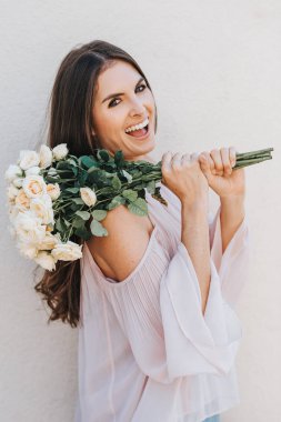 Allık soğuk omuz bluz giyen mutlu güzel kadın yumuşak beyaz güllü