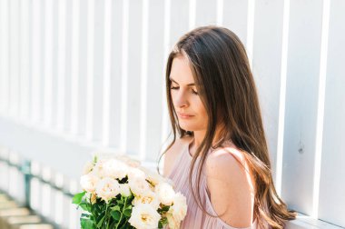 Allık soğuk omuz bluz giyen mutlu güzel kadın yumuşak beyaz güllü