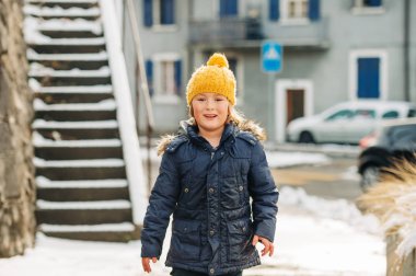 Açık kış zaman zevk sıcak ceket ve sarı şapka giyen genç 6 yaşında bir çocuk portresi