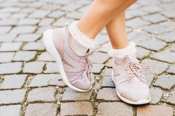 Yeni rahat eğitmenler ve yumuşak pembe giyen kadın çorap fırfır, görüntü kadar yakın