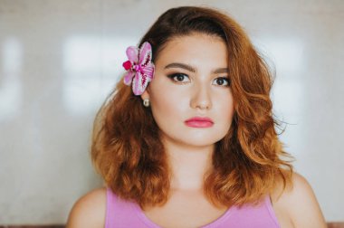 Güzel karışık ırk kadın, kulağın arkasına orkide çiçek portresi kapatın