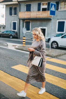 Güzel kadın smartphone kullanırken yol geçtikten