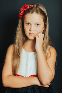 Sevimli küçük kız giyiyor fırsat Studio atış elbise, siyah arka plan üzerine poz