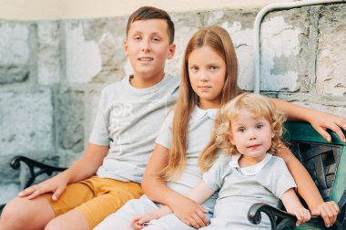 Grup Genç çocuk, küçük kız ve yürümeye başlayan çocuk, sarılmalar ve sevgi ile bir tezgah, aile üzerinde oturan 3 mutlu çocuk