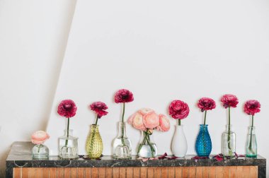 Ev dekorasyon, birçok farklı vazo beyaz karşı rafta buttercup çiçekli duvar boş.