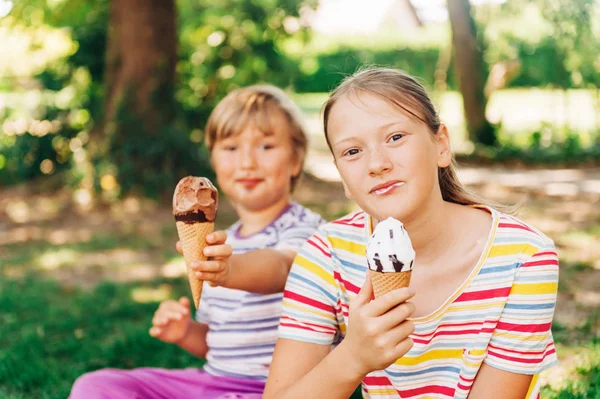 Dos Niños Divertidos Comiendo Helado Parque Verano Sentados Hierba Usando — Foto de Stock