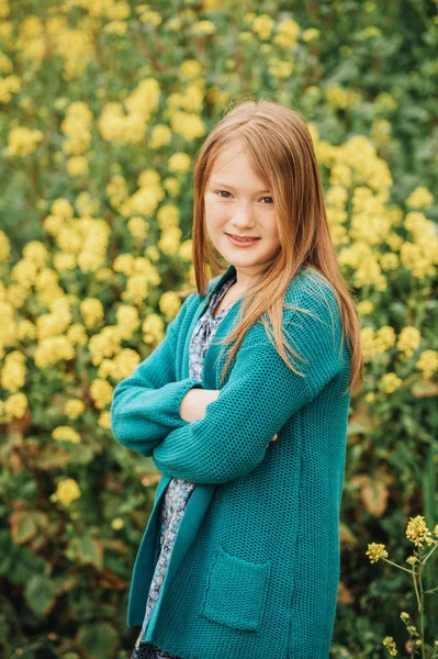 かわいい 歳の少女黄色の花のフィールドで遊んで 身に着けている緑のカーディガン 腕を組んでの露天の肖像画 — ストック写真
