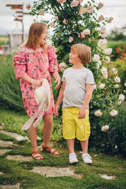 Yaz çiçek bahçesinde poz güzel güneşli bir günde iki şık çocuk portresi