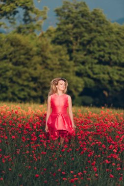 İyi günler haşhaş alanında zevk, kırmızı elbise giyen güzel bir kadın