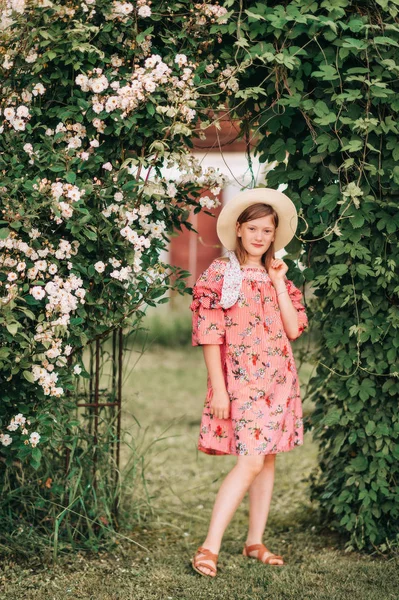 穿着红色条纹连衣裙 摆在玫瑰花园的漂亮小女孩的夏季肖像 — 图库照片