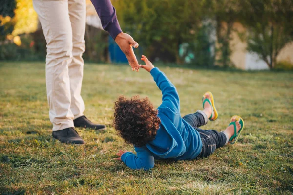 Father Giving Helping Hand His Son Lying Ground — Stock Photo, Image