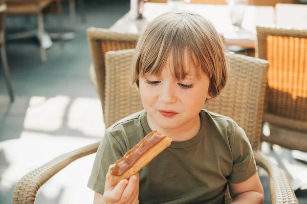 Bonito Menino Comendo Bolo Eclair Com Esmalte Caramelo — Fotografia de Stock