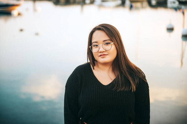 Outdoor portrait of asian plus size model posing by the lake