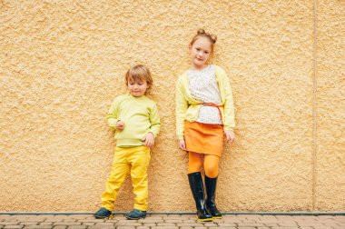 Açık sarı kıyafetlerle çok güzel moda çocuklar portresi