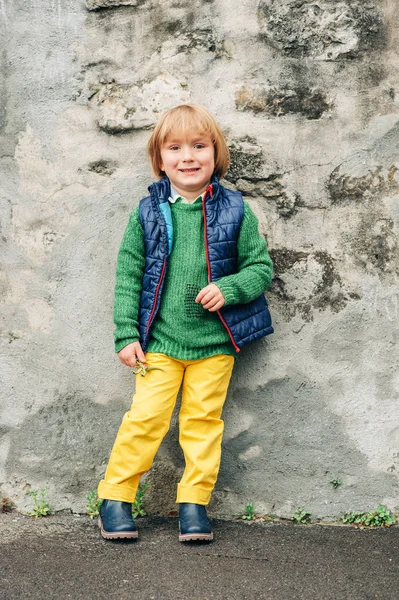 緑プルオーバー黄色ズボンとブーツ青いチョッキを着て 愛らしい小さな 歳男の子のアウトドアファッションの肖像画 — ストック写真