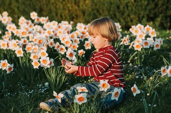 Söt Liten Pojke Leker Med Påsklilja Blommor Vårträdgård — Stockfoto