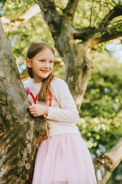 可爱的小女孩在公园里玩攀爬在树上 — 图库照片