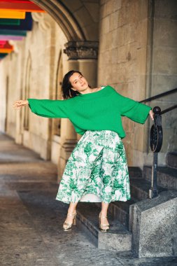 Koyu saçlı güzel kadın Açık moda portre, uzun vintage tarz yeşil etek ve pullover giyiyor, şehir caddesinde poz