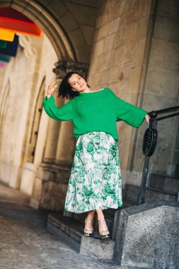 Koyu saçlı güzel kadın Açık moda portre, uzun vintage tarz yeşil etek ve pullover giyiyor, şehir caddesinde poz
