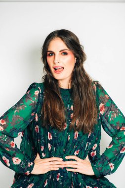 Uzun koyu saçlı, parlak pembe makyaj, yeşil elbise giyen, bel ellerini tutmak ile güzel kadın Stüdyo çekim