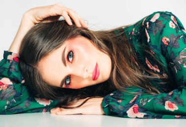 Uzun koyu saçlı, parlak pembe makyaj, yeşil elbise giyen güzel kadın Stüdyo çekim