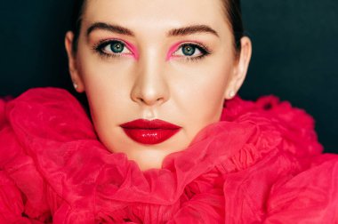 Parlak moda makyaj ile güzel genç modelin yakın portresi, büyük pembe kabarık yaka giyiyor