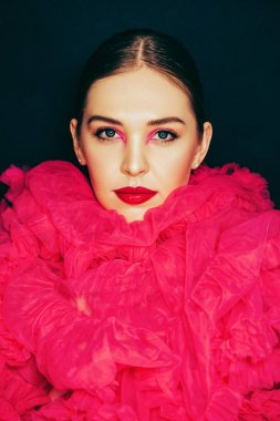 Parlak moda makyaj ile güzel genç modelin yakın portresi, büyük pembe kabarık yaka giyiyor
