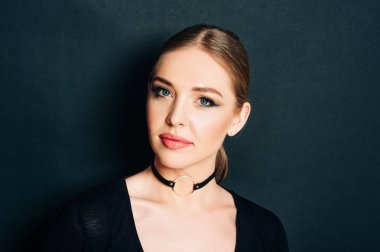 Siyah arka plan üzerinde poz, koyu profesyonel makyaj ile güzel genç kadının yakın portresi