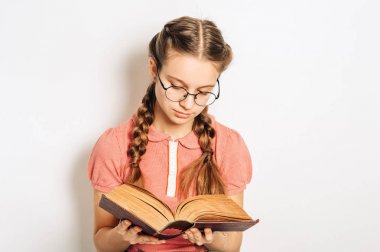 İki örgü ile sevimli preteen kız Stüdyo portre, ağır kitap tutan, gözlük giyen