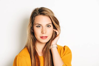 Sarı saçlı güzel genç kadının stüdyo çekimi, sarı pullover giyen, beyaz arka plan üzerinde poz