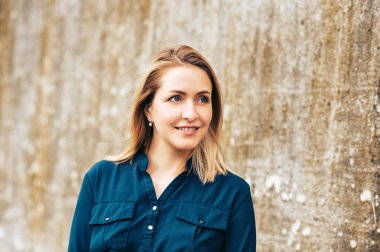 Sarı saçlı, mavi elbise giyen güzel genç kadının açık hava portresi