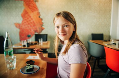 Asya restoranında suşi yiyen sevimli çocuk kız