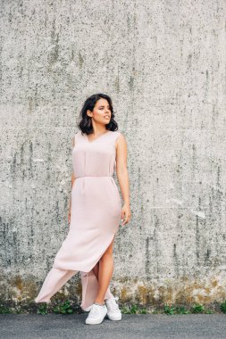 Gri duvar arka planda poz güzel genç kadının Kentsel moda portre